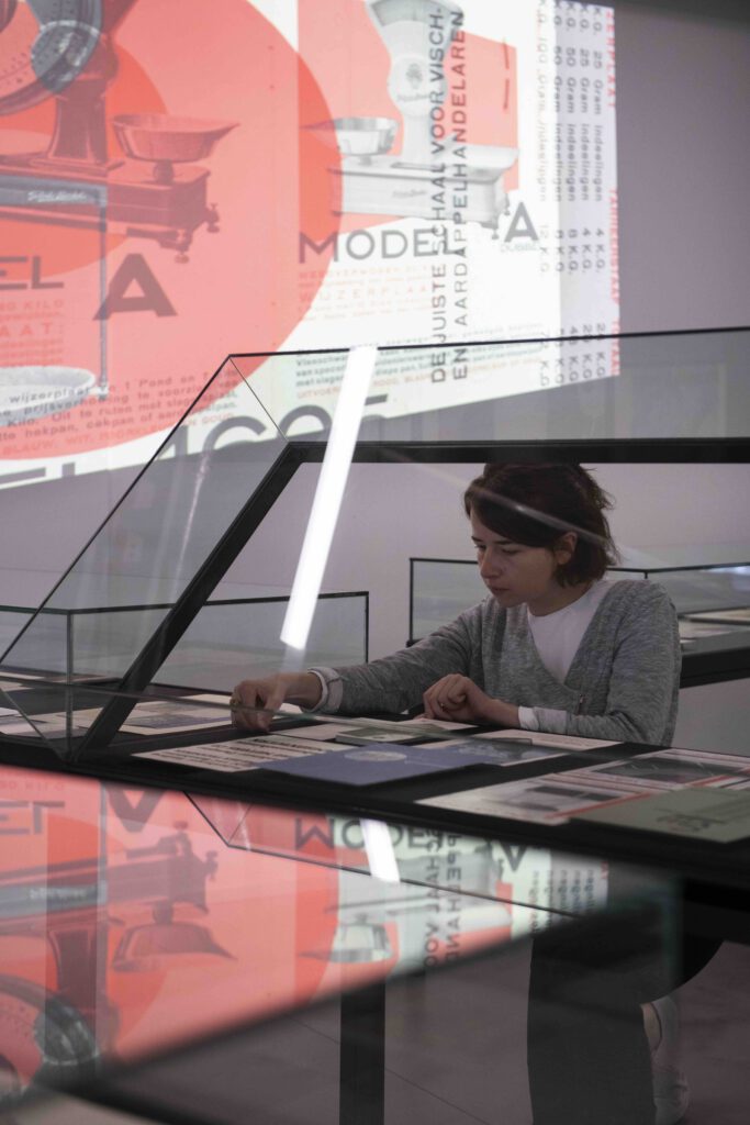 Linda Wößner bei der Vitrinenbestückung der Ausstellung "Revolutionäre der Typografie"
